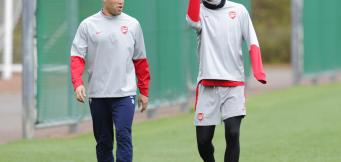 Arsenal's Mikael Silvestre, left, and Nicklas Bendtner walk to the pitch during their training session