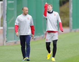 Arsenal's Mikael Silvestre, left, and Nicklas Bendtner walk to the pitch during their training session